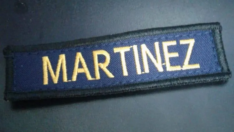Marquilla azul oscuro con apellido bordado en color dorado